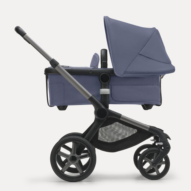 Side view of the Bugaboo Fox 5 bassinet stroller with graphite chassis, midnight black fabrics and stormy blue sun canopy. - Main Image Slide 2 of 12