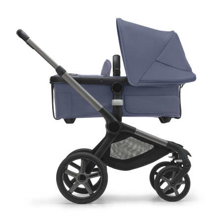 Side view of the Bugaboo Fox 5 bassinet stroller with graphite chassis, midnight black fabrics and stormy blue sun canopy.