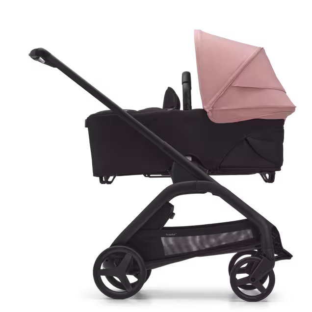 Side view of the Bugaboo Dragonfly bassinet stroller with black chassis, midnight black fabrics and morning pink sun canopy. - Main Image Slide 3 of 16