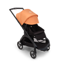Bugaboo Dragonfly seat stroller with black chassis, midnight black fabrics and island coral sun canopy. The sun canopy is fully extended.