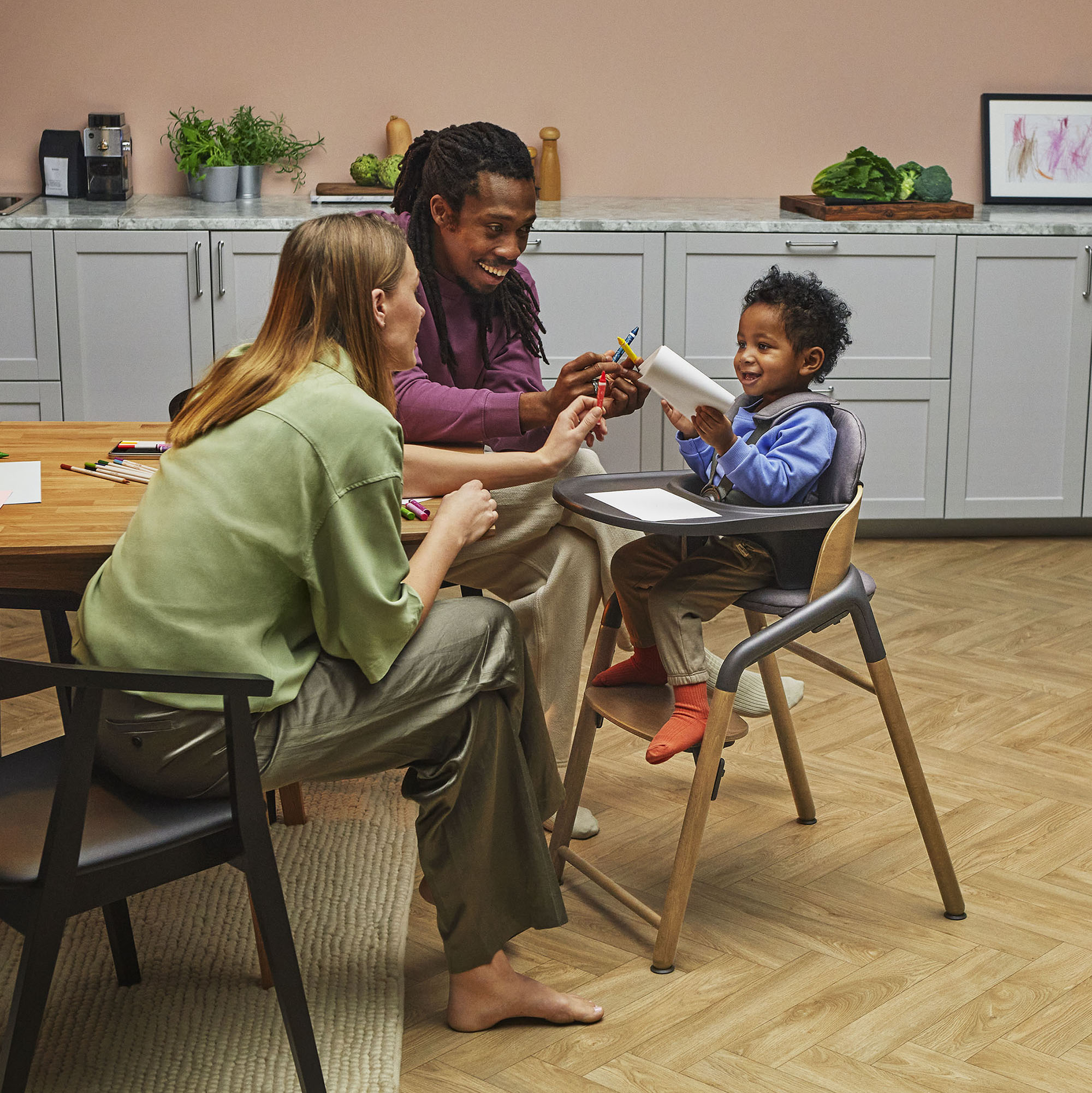 Mom and dad playing with toddler in a Bugaboo Giraffe high chair with baby set and tray. - Thumbnail Slide 2 of 6
