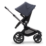 Side view of the Bugaboo Fox 5 seat stroller with graphite chassis, midnight black fabrics and stormy blue sun canopy.