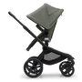 Side view of the Bugaboo Fox 5 seat stroller with black chassis, forest green fabrics and forest green sun canopy.