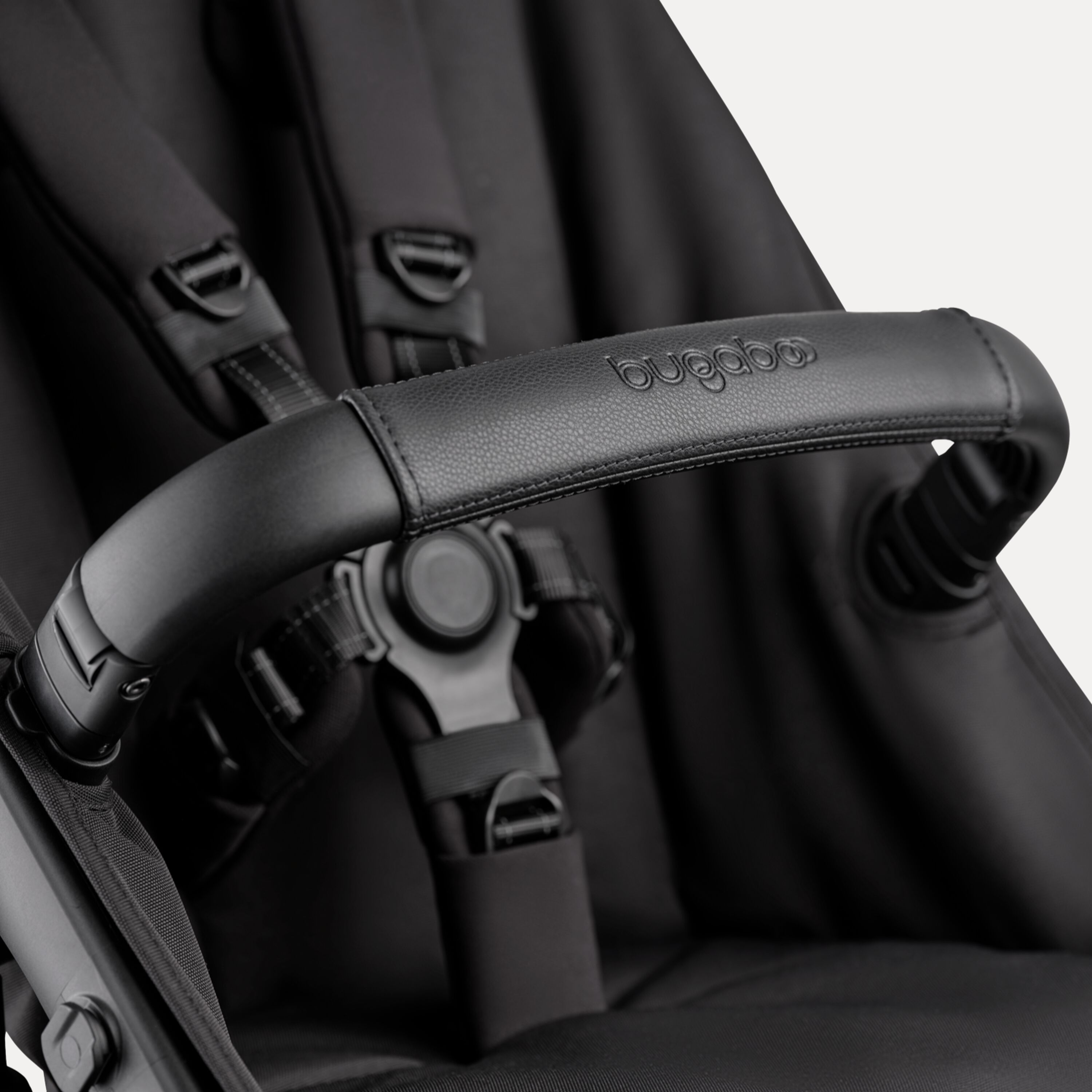 A close-up of the seat of the Bugaboo Kangaroo 2-in-1 stroller, with focus on the carry handle and the five-point safety harness. - Main Modal Image Slide 15 of 18