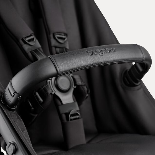 A close-up of the seat of the Bugaboo Kangaroo 2-in-1 stroller, with focus on the carry handle and the five-point safety harness. - Main Image Slide 15 of 18