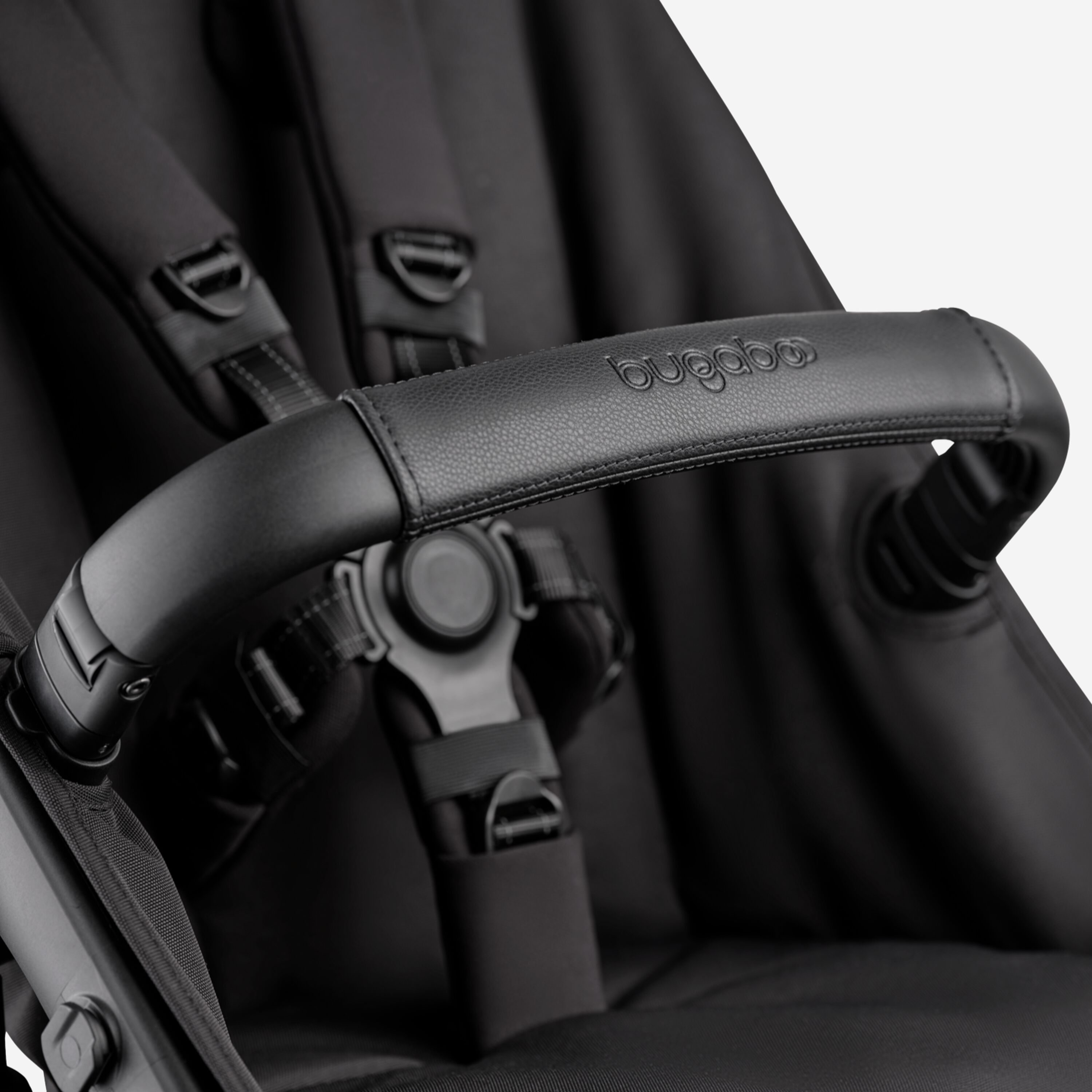 A close-up of the seat of the Bugaboo Kangaroo 2-in-1 stroller, with focus on the carry handle and the five-point safety harness. - Main Modal Image Slide 15 of 18