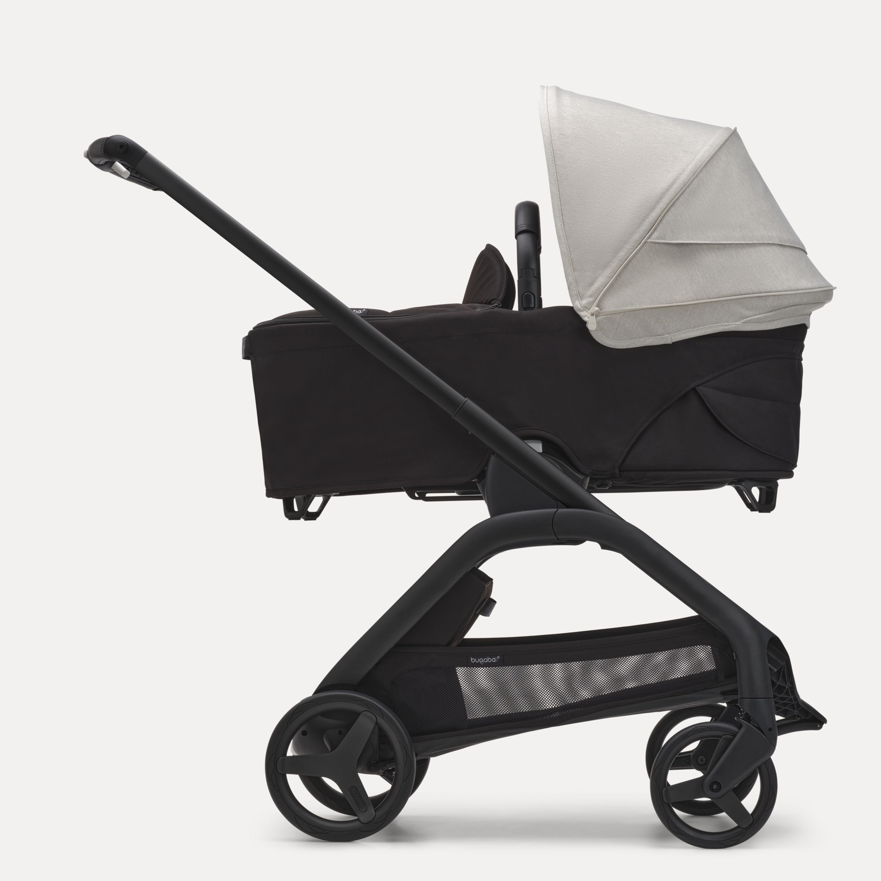 Side view of the Bugaboo Dragonfly bassinet stroller with black chassis, midnight black fabrics and misty white sun canopy. - Main Modal Image Slide 3 of 16