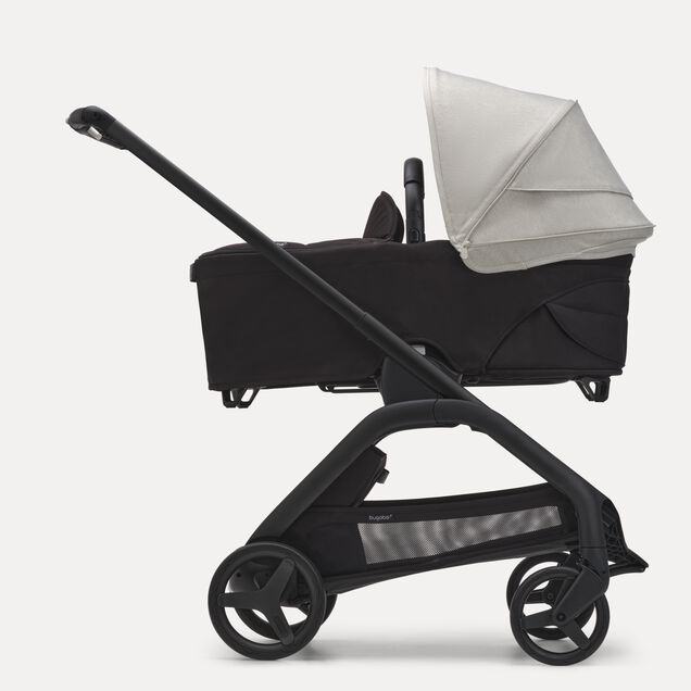 Side view of the Bugaboo Dragonfly bassinet stroller with black chassis, midnight black fabrics and misty white sun canopy. - Main Image Slide 3 of 16