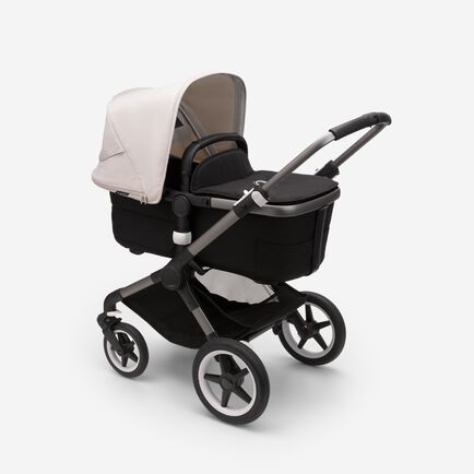 Bugaboo Fox 3 bassinet stroller with graphite frame, black fabrics, and white sun canopy.