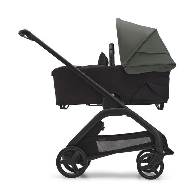Side view of the Bugaboo Dragonfly bassinet stroller with black chassis, midnight black fabrics and forest green sun canopy.