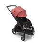 Bugaboo Dragonfly seat stroller with black chassis, midnight black fabrics and sunrise red sun canopy. The sun canopy is fully extended.