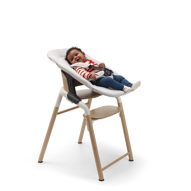Baby in a Bugaboo Giraffe chair with newborn set.