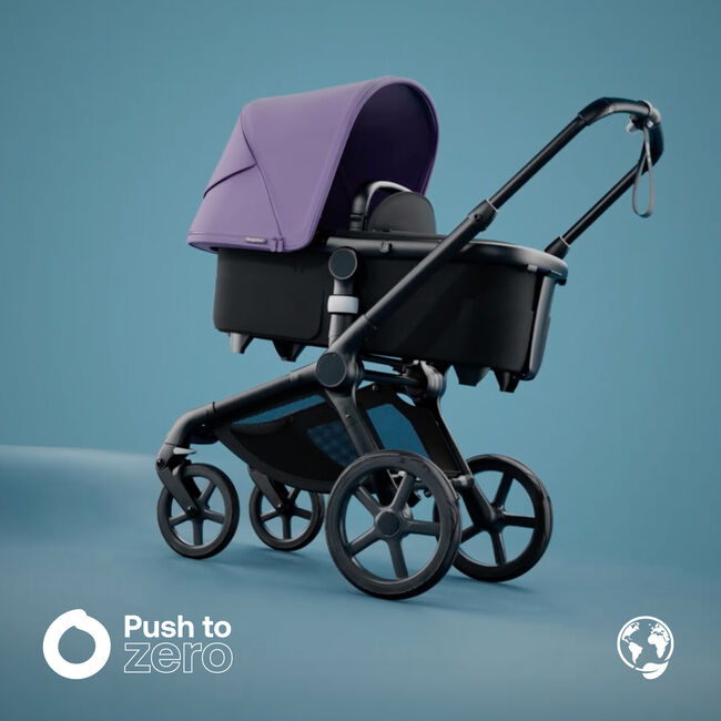 Bugaboo Fox 5 bassinet stroller with astro purple sun canopy; in the left bottom corner is the Push to Zero logo.