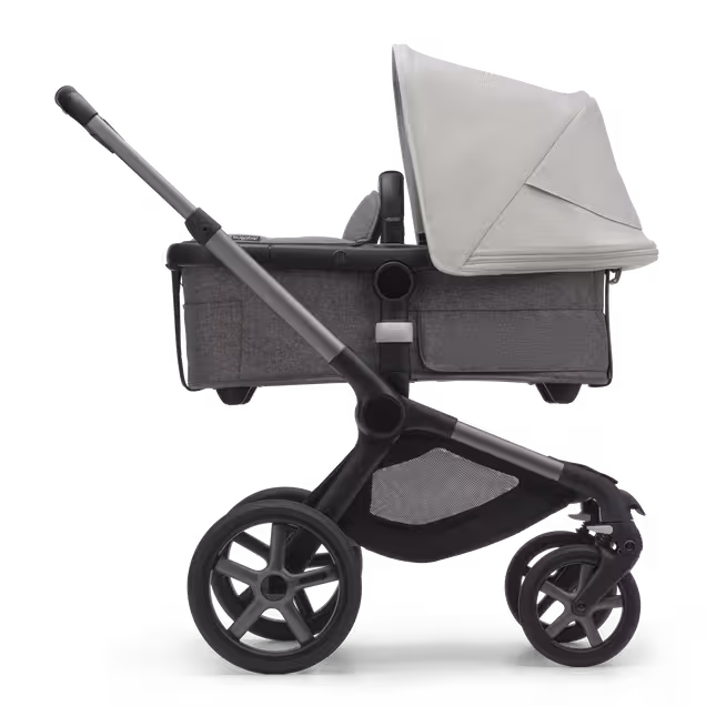 Side view of the Bugaboo Fox 5 carrycot pushchair with graphite chassis, grey melange fabrics and misty white sun canopy. - Main Image Slide 2 of 13