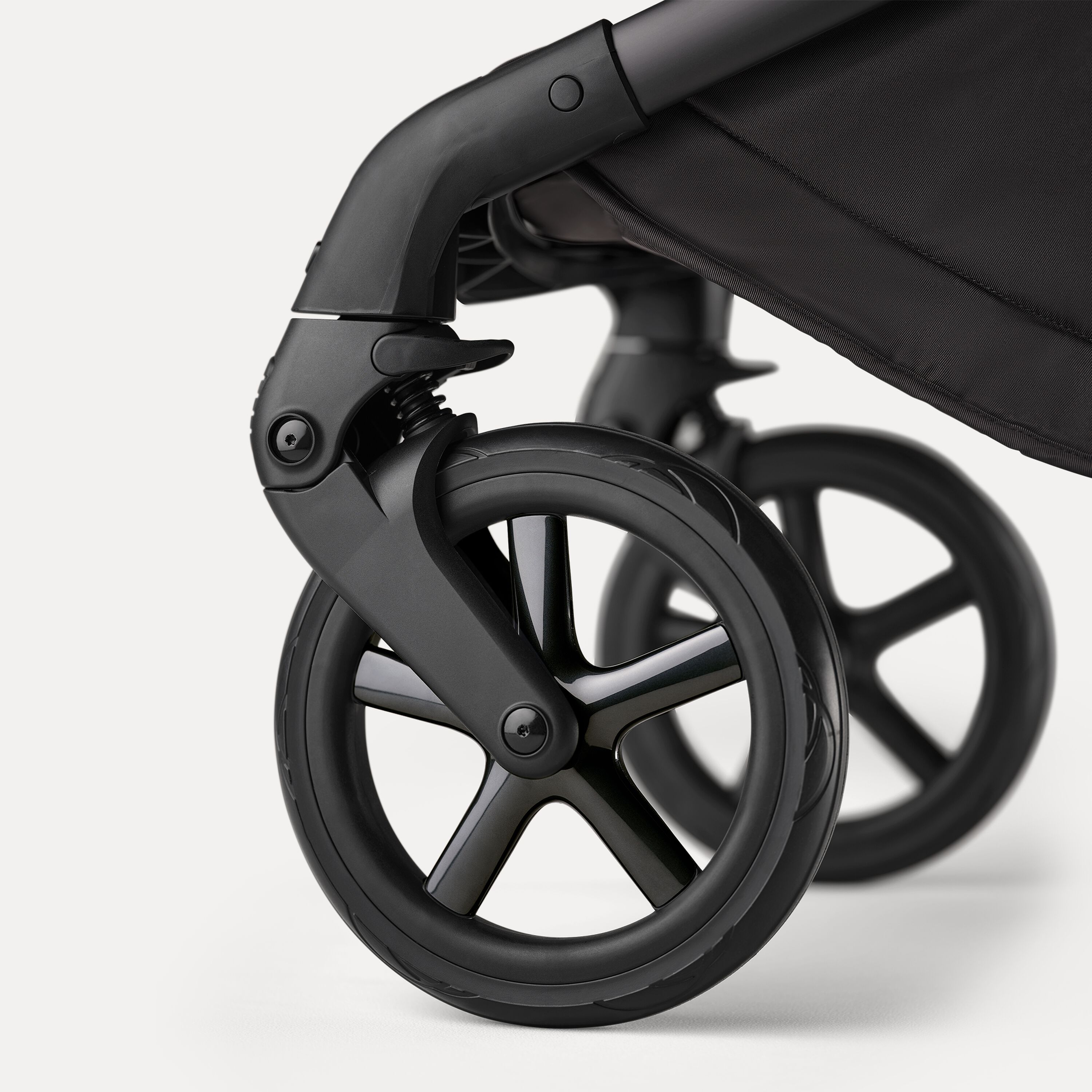 A close up of the wheels of the Bugaboo Fox 5 Noir Limited Edition Black Moonlight. The wheel caps have polished rims. - Main Modal Image Slide 12 of 15
