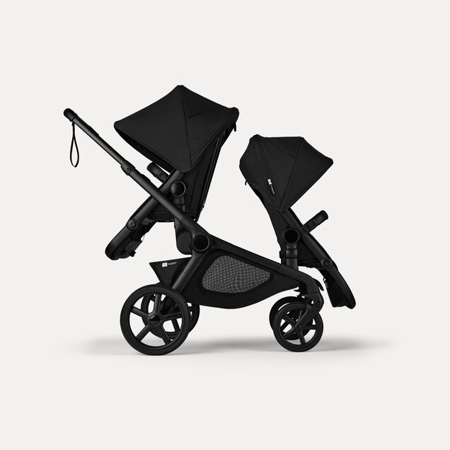 Side view of Bugaboo Kangaroo 2-in-1 tandem stroller with two seats, one facing parent and the other facing the world, with Midnight Black fabrics and Midnight Black sun canopies. - Main Image Slide 4 of 18