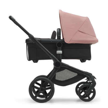 Side view of the Bugaboo Fox 5 bassinet stroller with black chassis, midnight black fabrics and morning pink sun canopy. - view 2