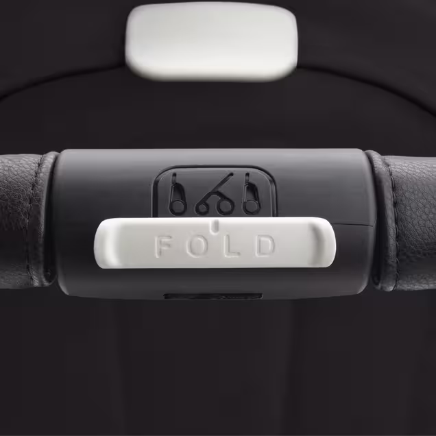 Close up on the Bugaboo Dragonfly stroller's handlebar, focusing on the big white 'Fold' button. - Main Image Slide 14 of 16