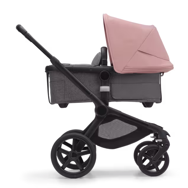 Side view of the Bugaboo Fox 5 carrycot pushchair with black chassis, grey melange fabrics and morning pink sun canopy. - Main Image Slide 2 of 13