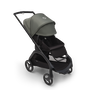 Bugaboo Dragonfly seat stroller with black chassis, midnight black fabrics and forest green sun canopy. The sun canopy is fully extended.