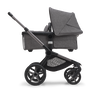 Side view of the Bugaboo Fox 5 bassinet stroller with graphite chassis, grey melange fabrics and grey melange sun canopy.