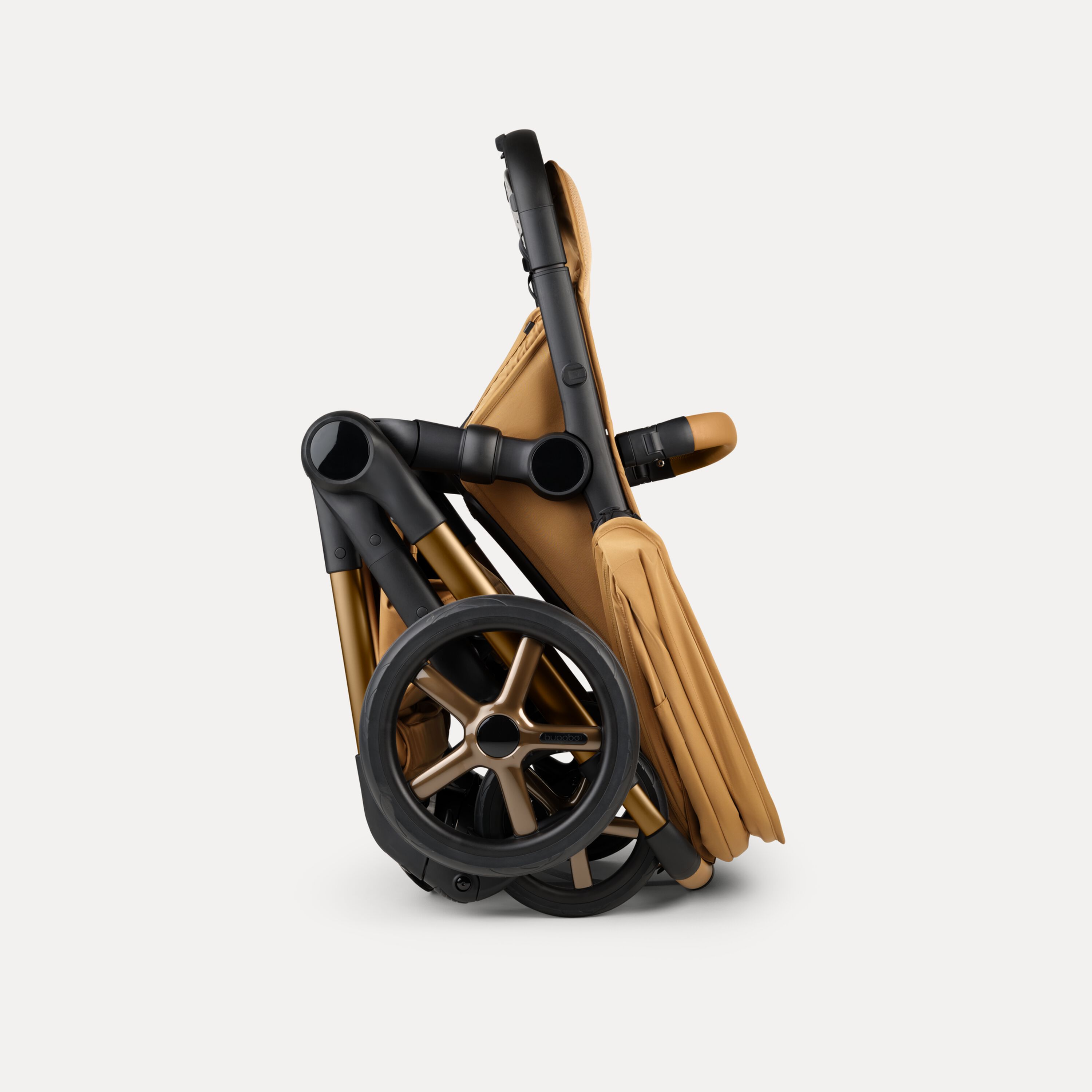 A Bugaboo Fox 5 Noir Limited Edition stroller in Amber Glow, shown in a folded position. - Main Modal Image Slide 10 of 15