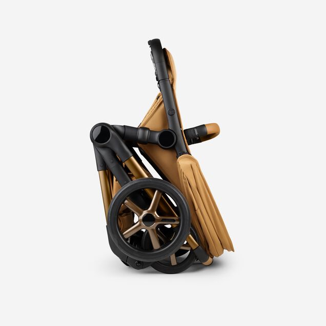 A Bugaboo Fox 5 Noir Limited Edition stroller in Amber Glow, shown in a folded position. - Main Image Slide 10 of 15