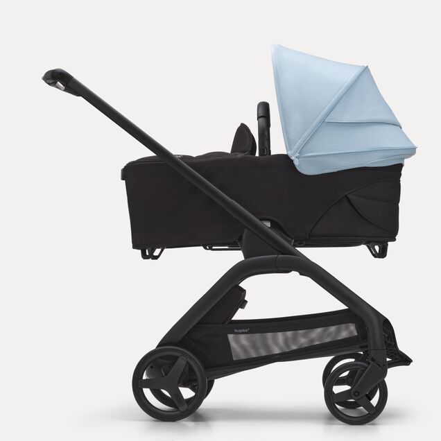 Side view of the Bugaboo Dragonfly bassinet stroller with black chassis, midnight black fabrics and skyline blue sun canopy. - Main Image Slide 3 of 16