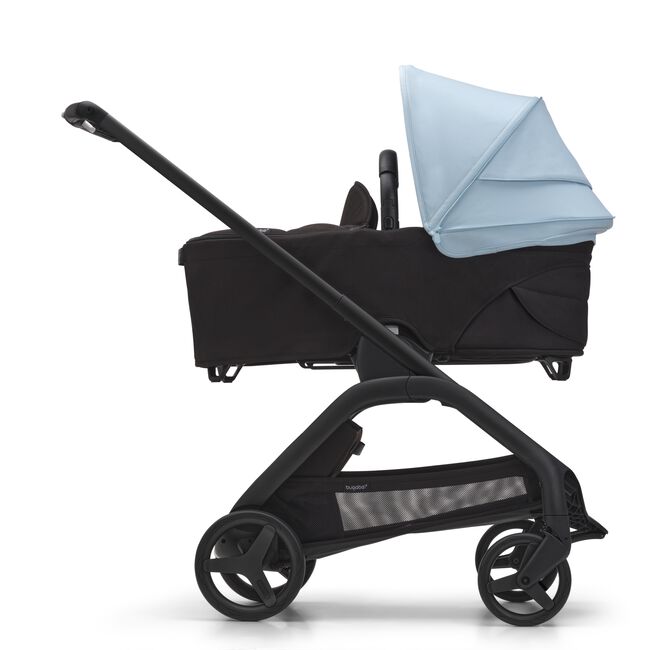 Side view of the Bugaboo Dragonfly bassinet stroller with black chassis, midnight black fabrics and skyline blue sun canopy.