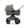 Bugaboo Fox 3 barnvagn med liggdel med grafitgrå ram, ljusgrå klädsel och sufflett sedd från sidan.