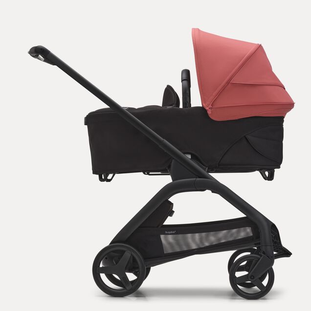Vista laterale del passeggino con navicella Bugaboo Dragonfly con telaio black, tessuti midnight black e cappottina sunrise red. - Main Image Slide 3 of 16