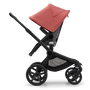 Side view of the Bugaboo Fox 5 seat stroller with black chassis, grey melange fabrics and sunrise red sun canopy.