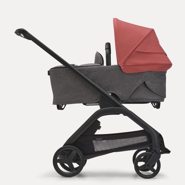 Side view of the Bugaboo Dragonfly bassinet stroller with black chassis, grey melange fabrics and sunrise red sun canopy. - Main Image Slide 3 of 16