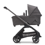 Side view of the Bugaboo Dragonfly carrycot pushchair with graphite chassis, grey melange fabrics and grey melange sun canopy. - Thumbnail Slide 4 of 18