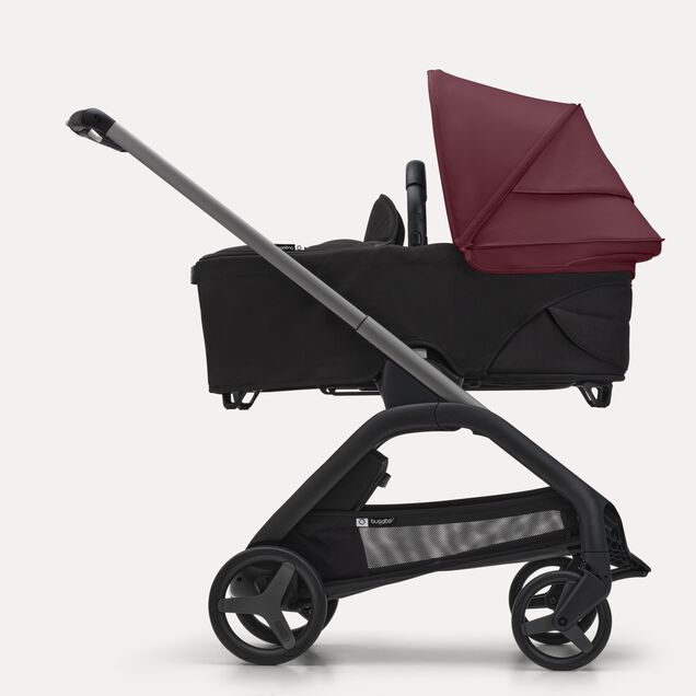 Side view of the Bugaboo Dragonfly bassinet stroller with black chassis, grey melange fabrics and grey melange sun canopy. - Main Image Slide 3 of 16