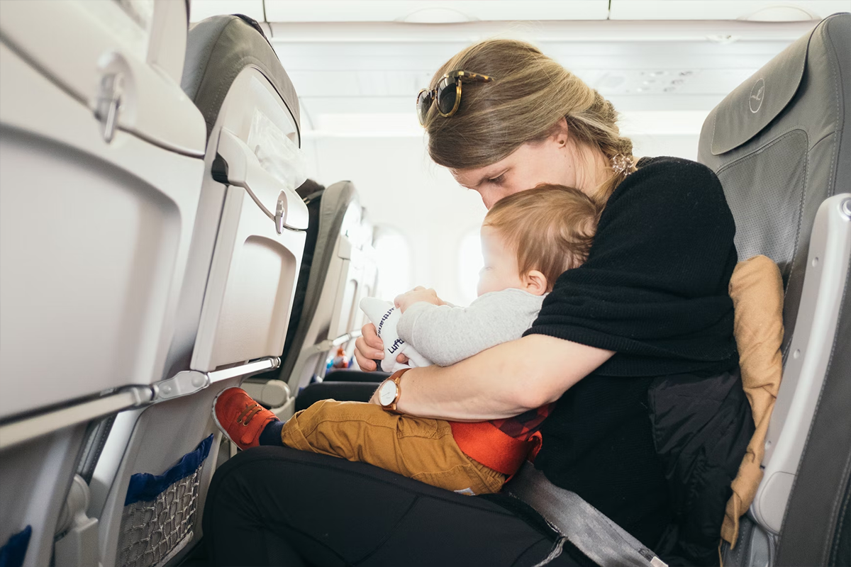Mother carrying baby on her lap during a flight
