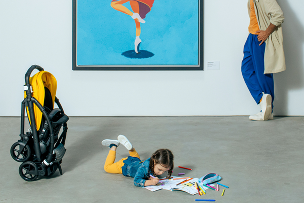 A dad looks at his daughter coloring on the floor