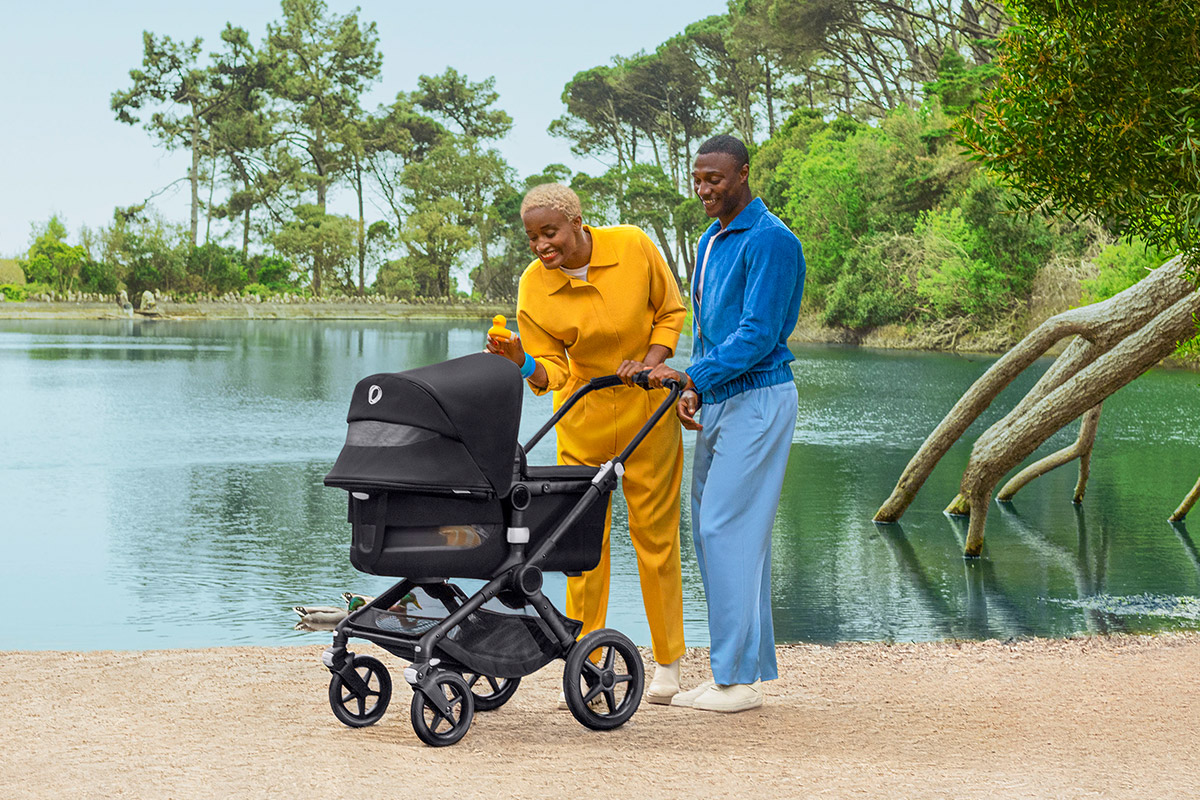 Man and woman with stroller by a lake