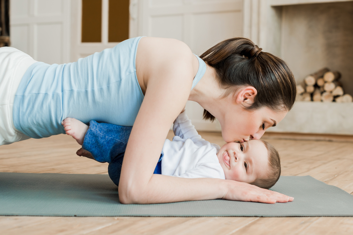 Mother doing planks with her baby