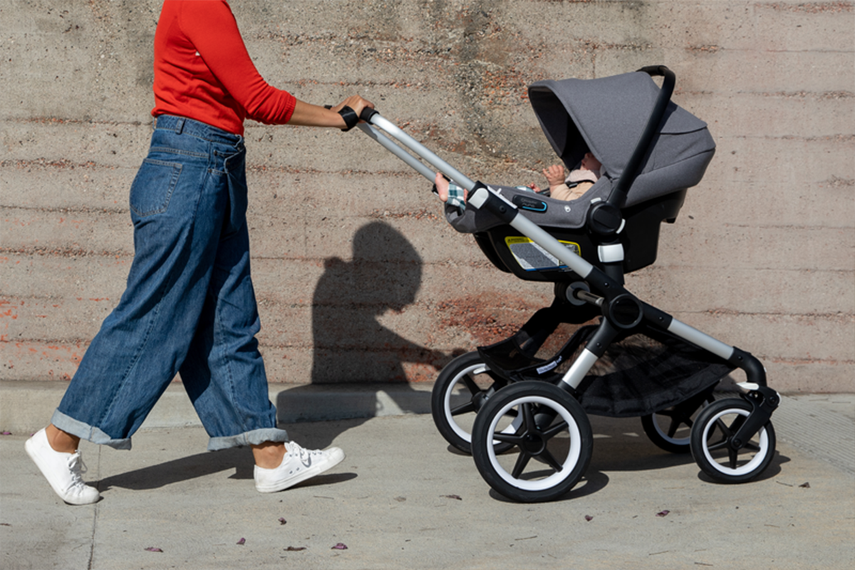Parent pushing baby in a Bugaboo stroller