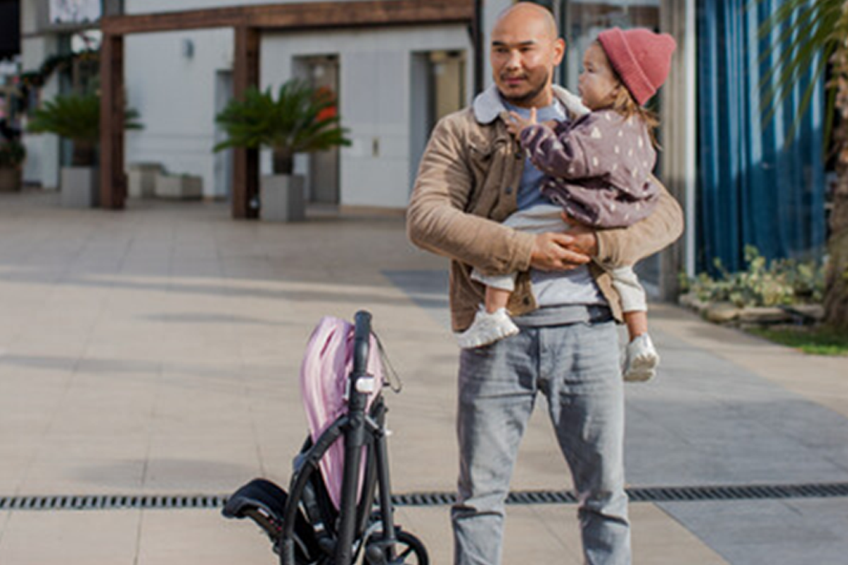 Dad with his daughter using self-standing compact stroller