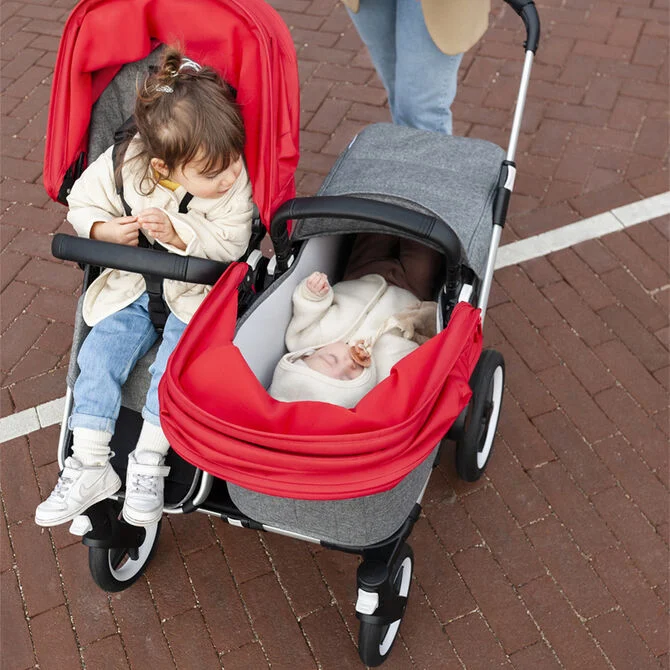 A toddler and a baby being pushed side-by-side in Bugaboo’s double buggy, Donkey Duo