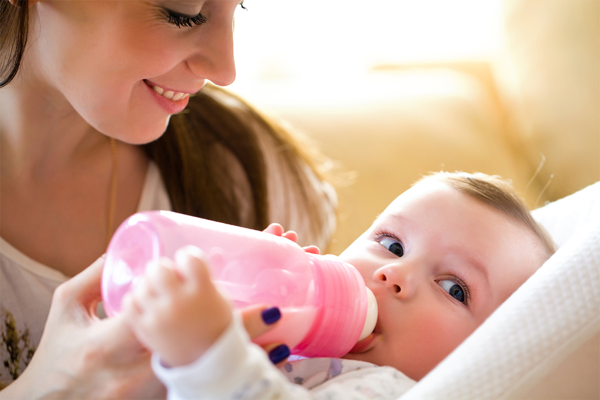 Mom feeding baby with a baby bottle