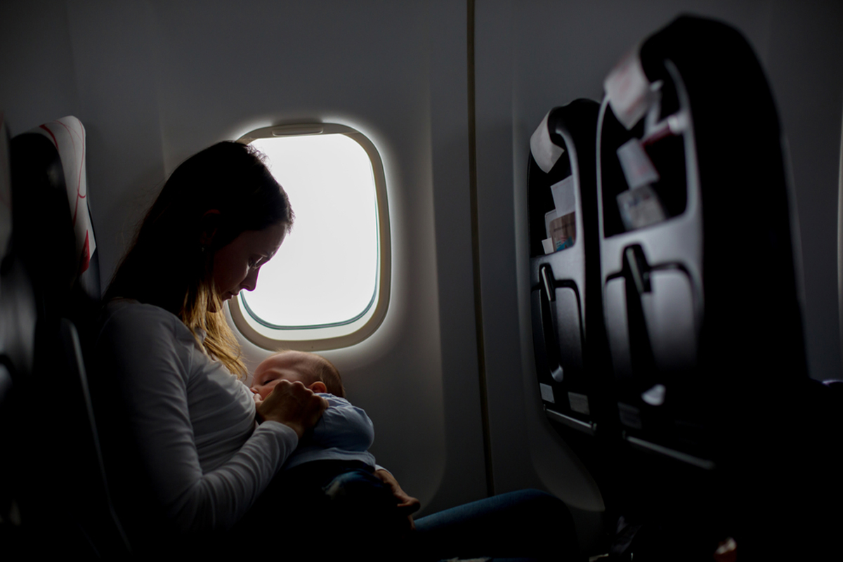 Mom breastfeeding while flying with a baby